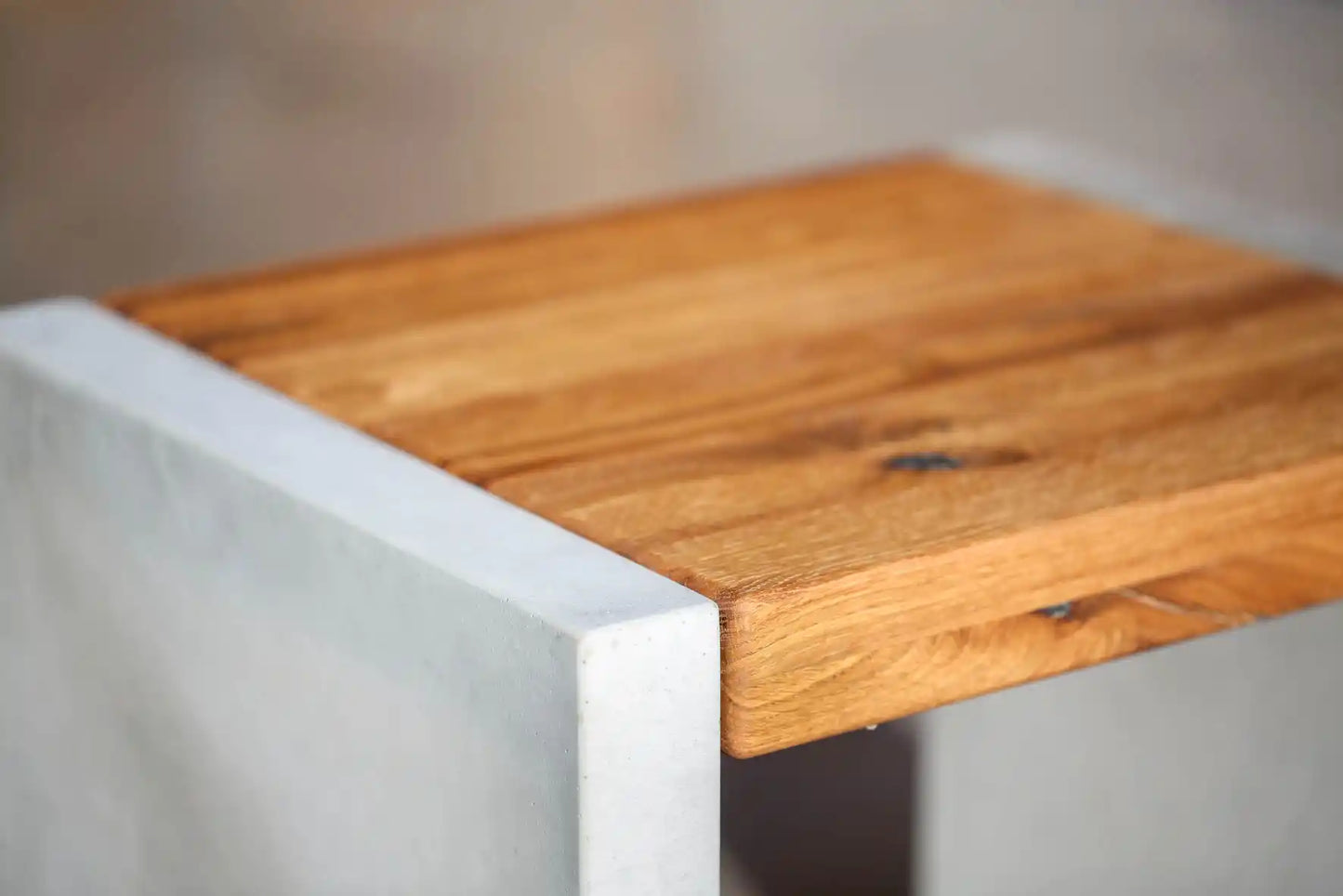 Hocker mit Sitzfläche aus Massivholz und Standfüßen aus Beton Detailansicht