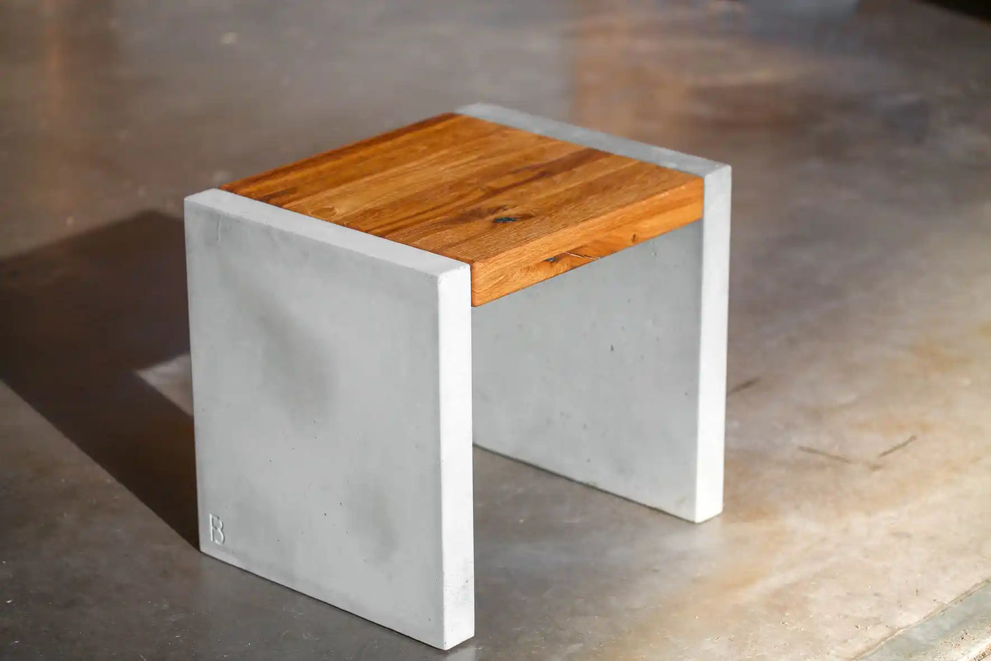 Hocker mit Sitzfläche aus Massivholz und Standfüßen aus Beton
