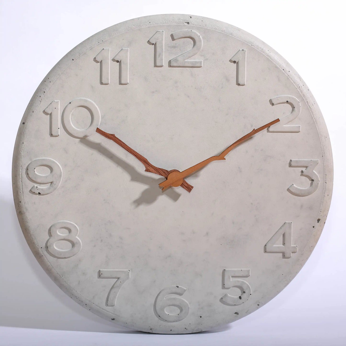 Wanduhr aus Beton mit Holzzeigern in Astform