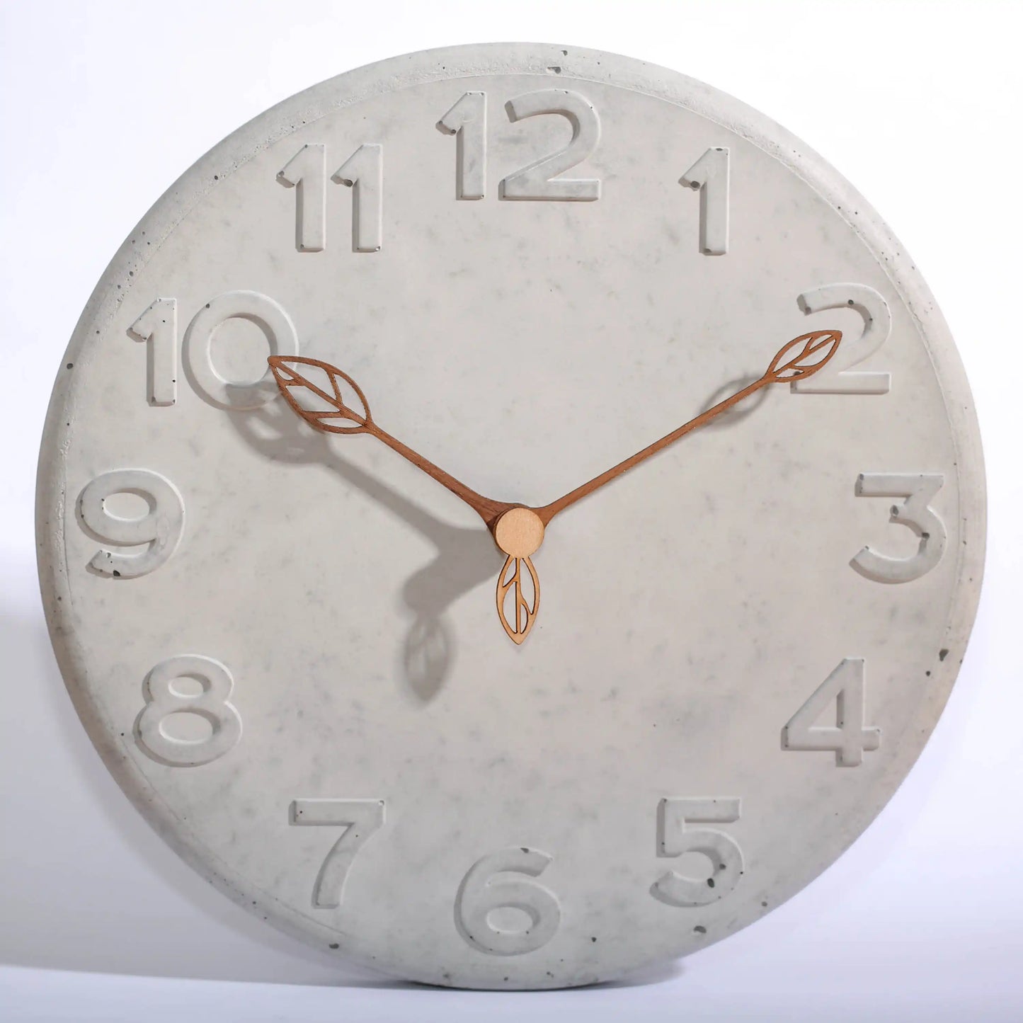 Wanduhr aus Beton mit Holzzeigern in Blattform