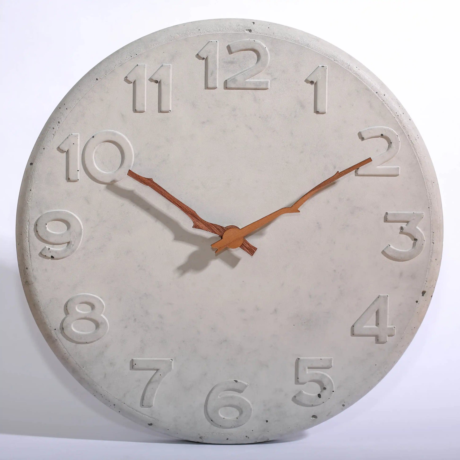 Wanduhr aus Beton mit Holzzeigern in Astform